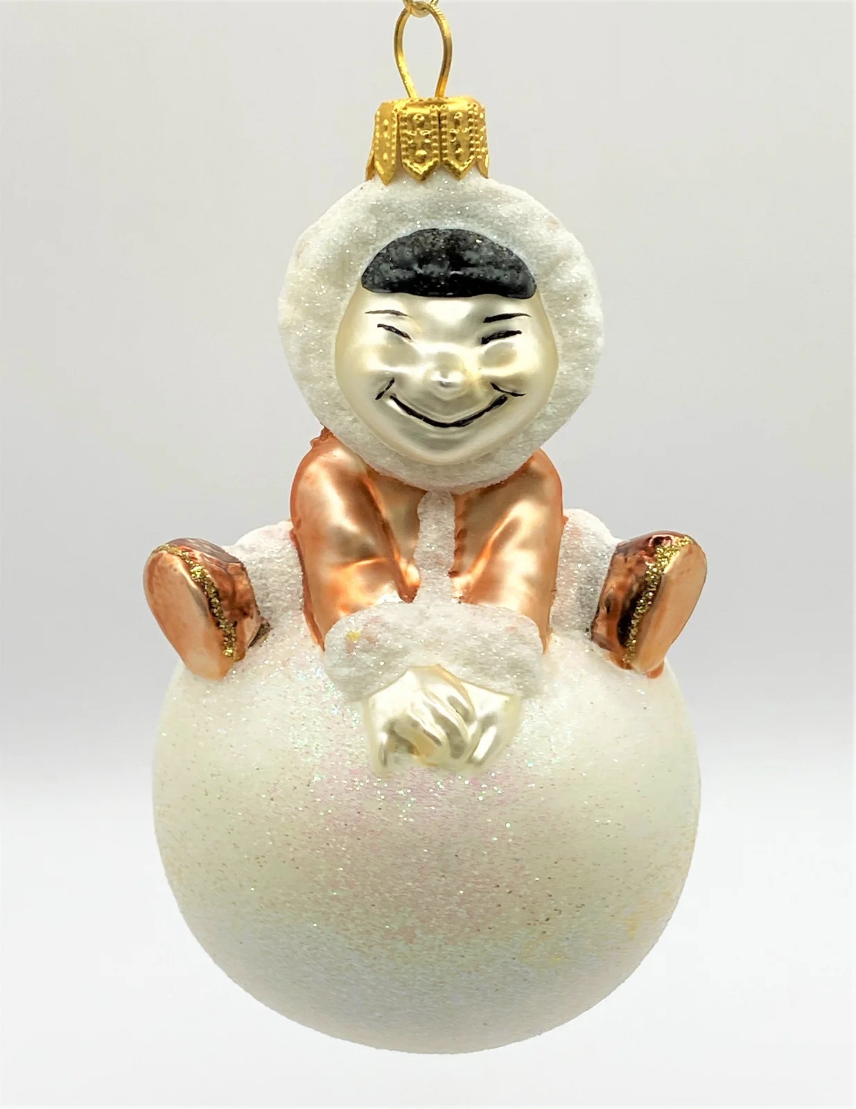 Sonstige Inuit Junge turnt auf einem Schneeball