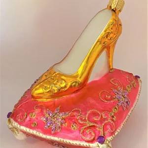 GMC Goldener High Heel auf rosa Brokatkissen