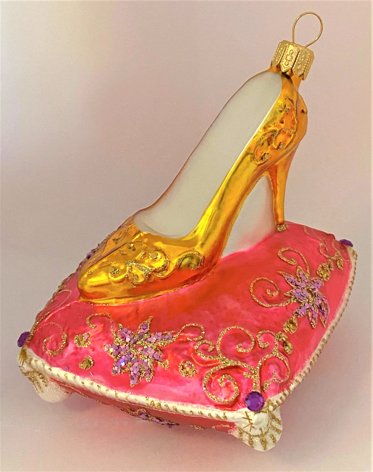 GMC Goldener High Heel auf rosa Brokatkissen