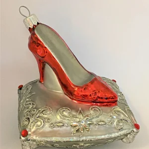 GMC Roter High Heels auf silbernem Brokatkissen