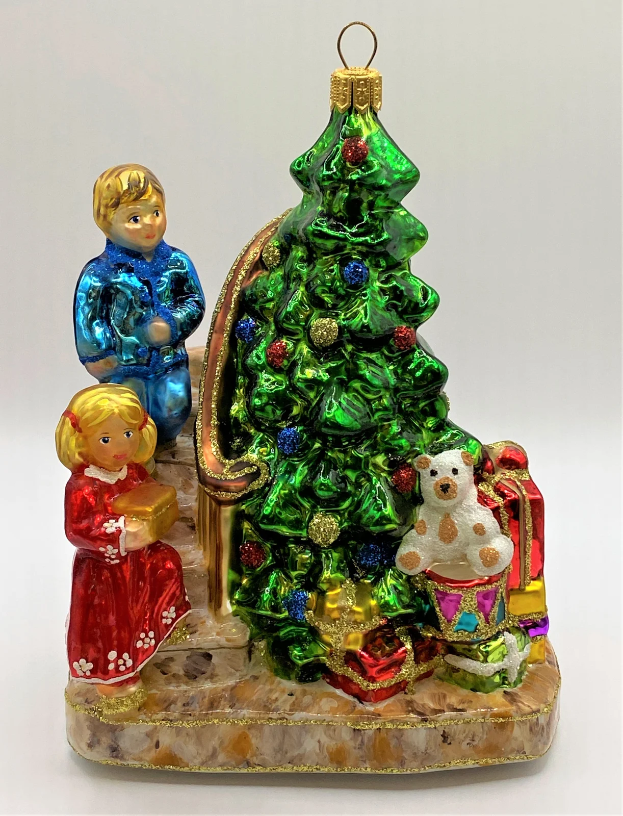 Glassware Die Kinder legen die Geschenke unter den Christbaum