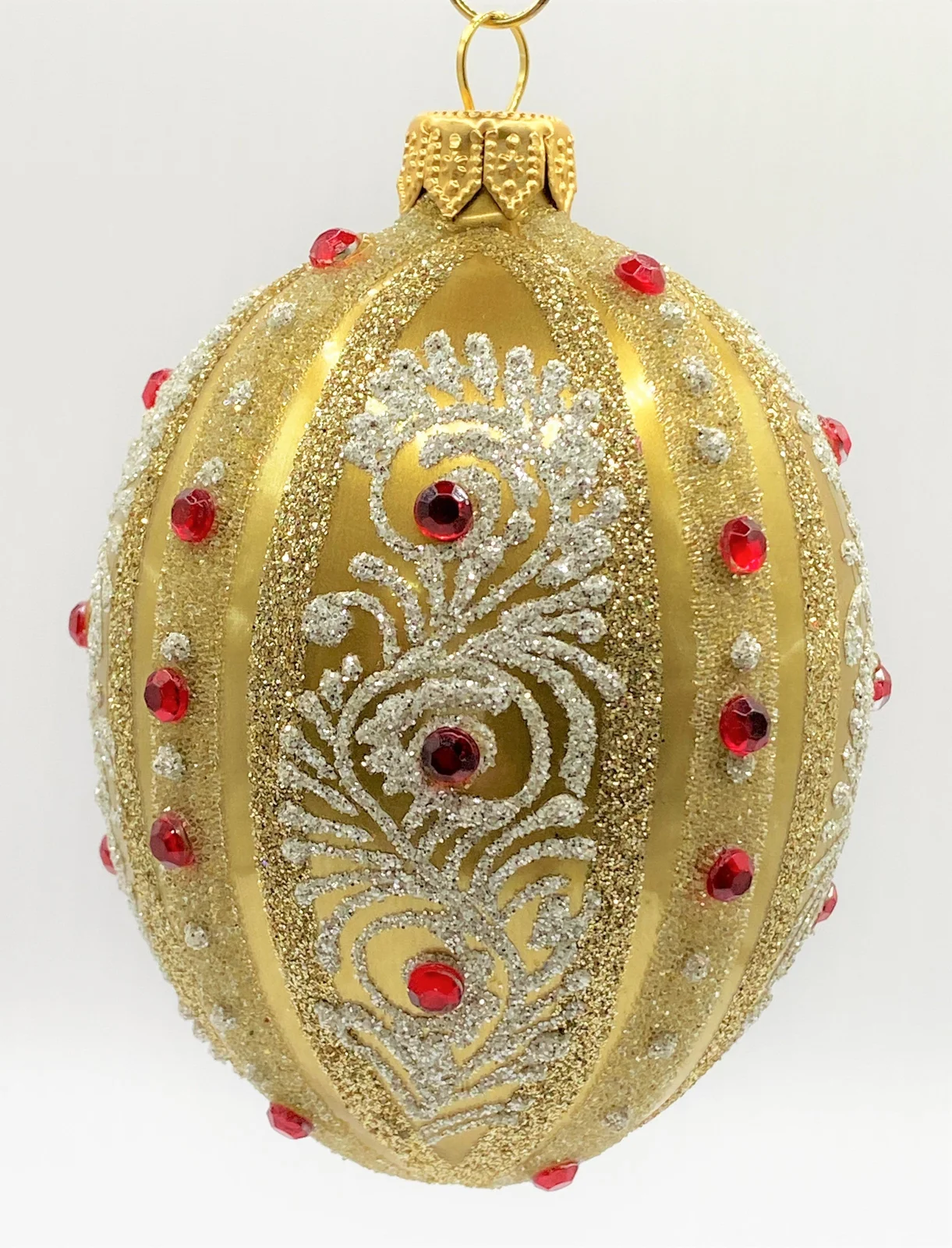 Dagmara Ei-Form gold mit weissem Dekor und roten Schmucksteinen