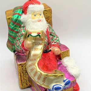 Glassware Santa Claus sitzt bequem im Sessel und studiert die Geschenke-Liste