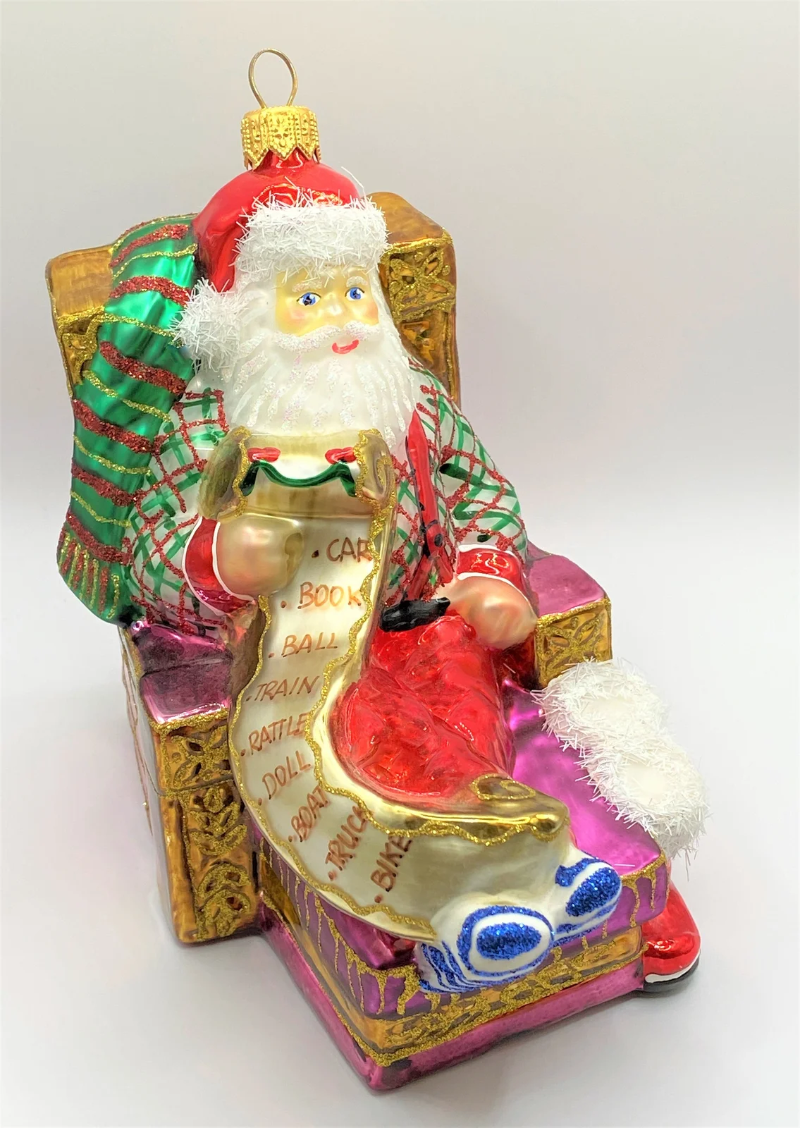 Glassware Santa Claus sitzt bequem im Sessel und studiert die Geschenke-Liste
