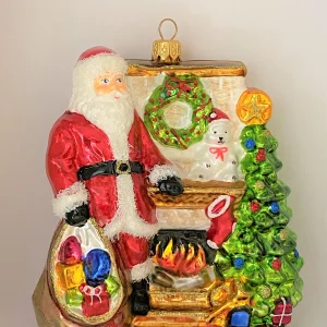 Glassware Santa Claus wärmt sich am Kaminfeuer auf