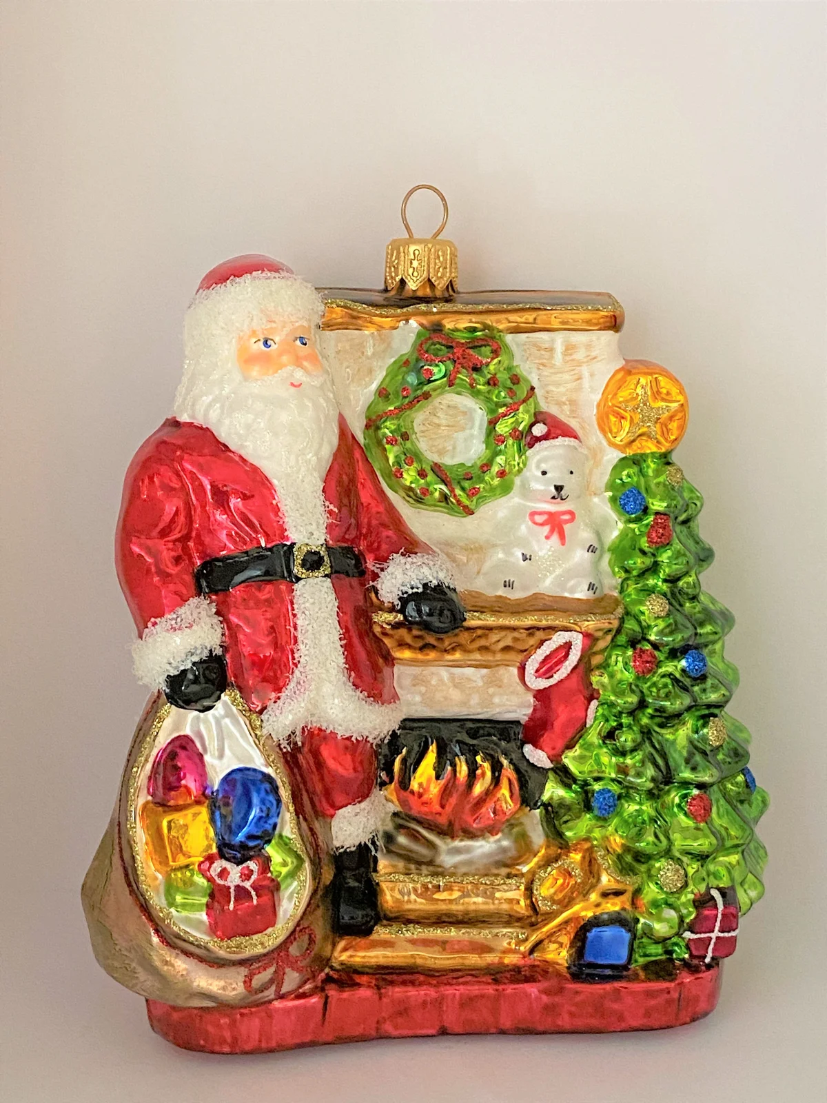 Glassware Santa Claus wärmt sich am Kaminfeuer auf