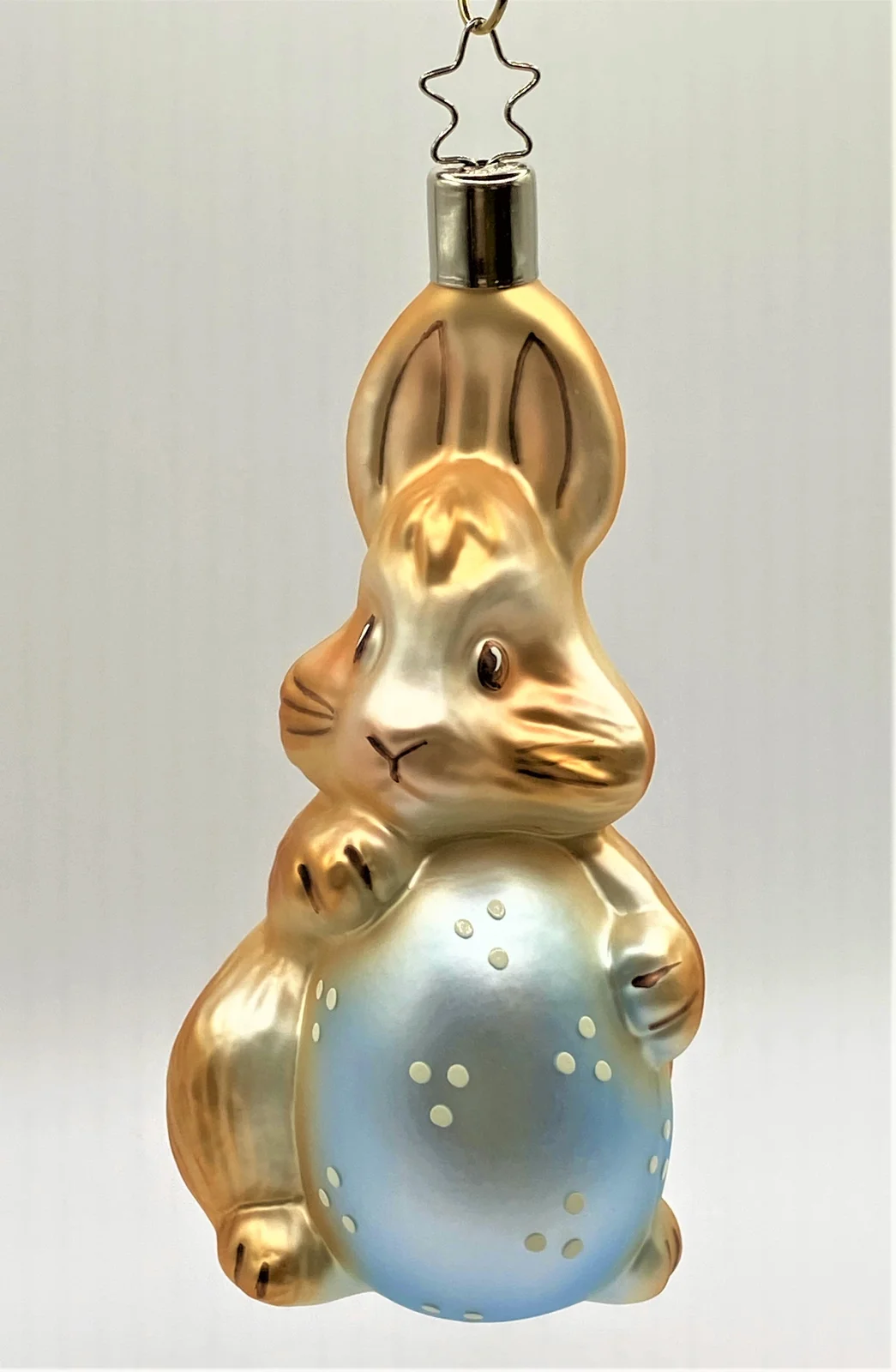 Inge-Glas Der Osterhase erfreut sich am hellblauen Osterei
