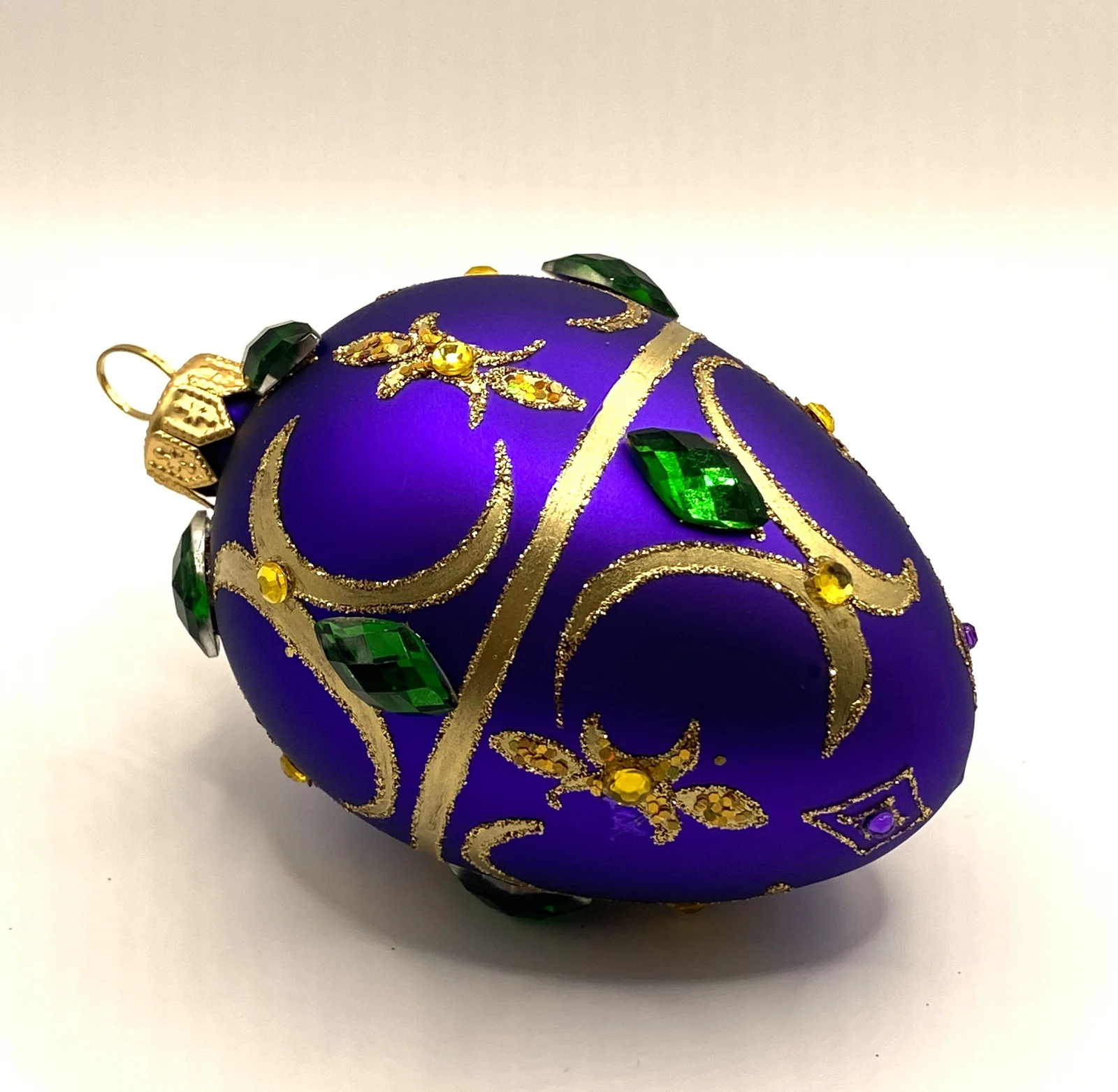GMC Ei-Form violett mit goldenem Dekor und grünen Schmucksteinen
