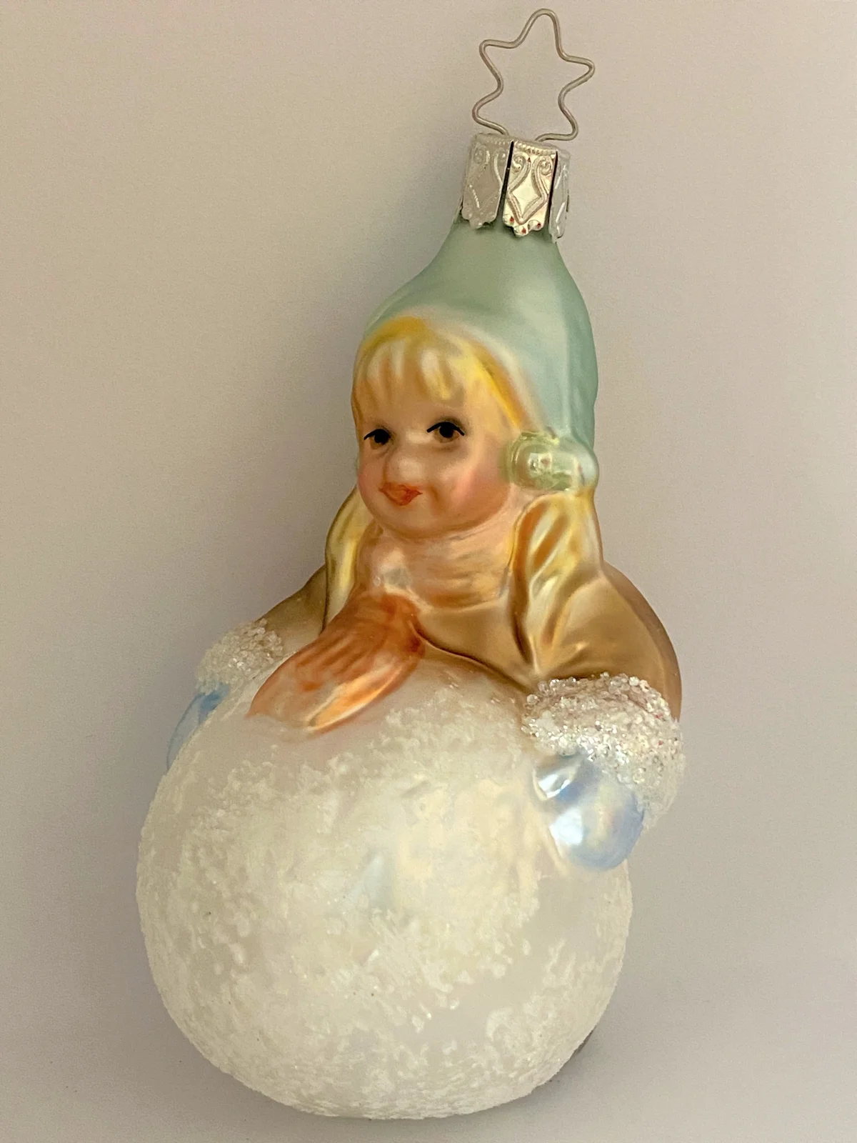 Inge-Glas Kleines Mädchen mit Wintermütze macht einen riesigen Schneeball, pastell