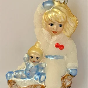 Christborn Mädchen fährt Schlitten mit der Puppe