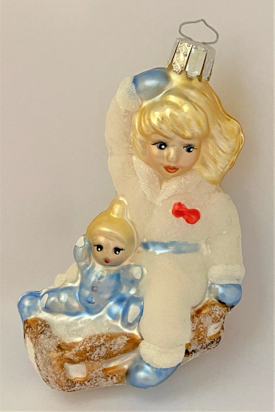 Christborn Mädchen fährt Schlitten mit der Puppe