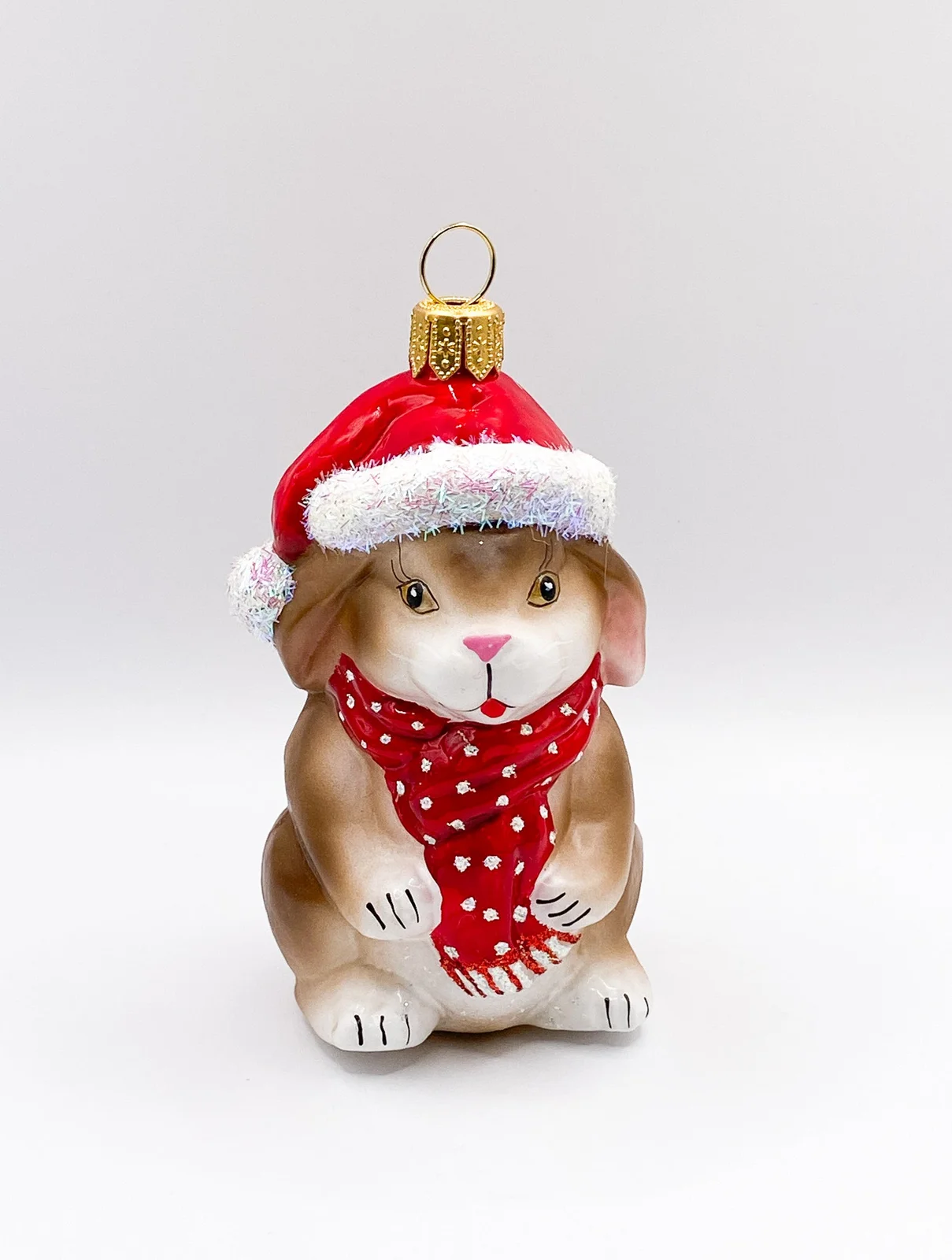 Hanco Kleiner braun-weisser Hase mit roter Mütze und Schal