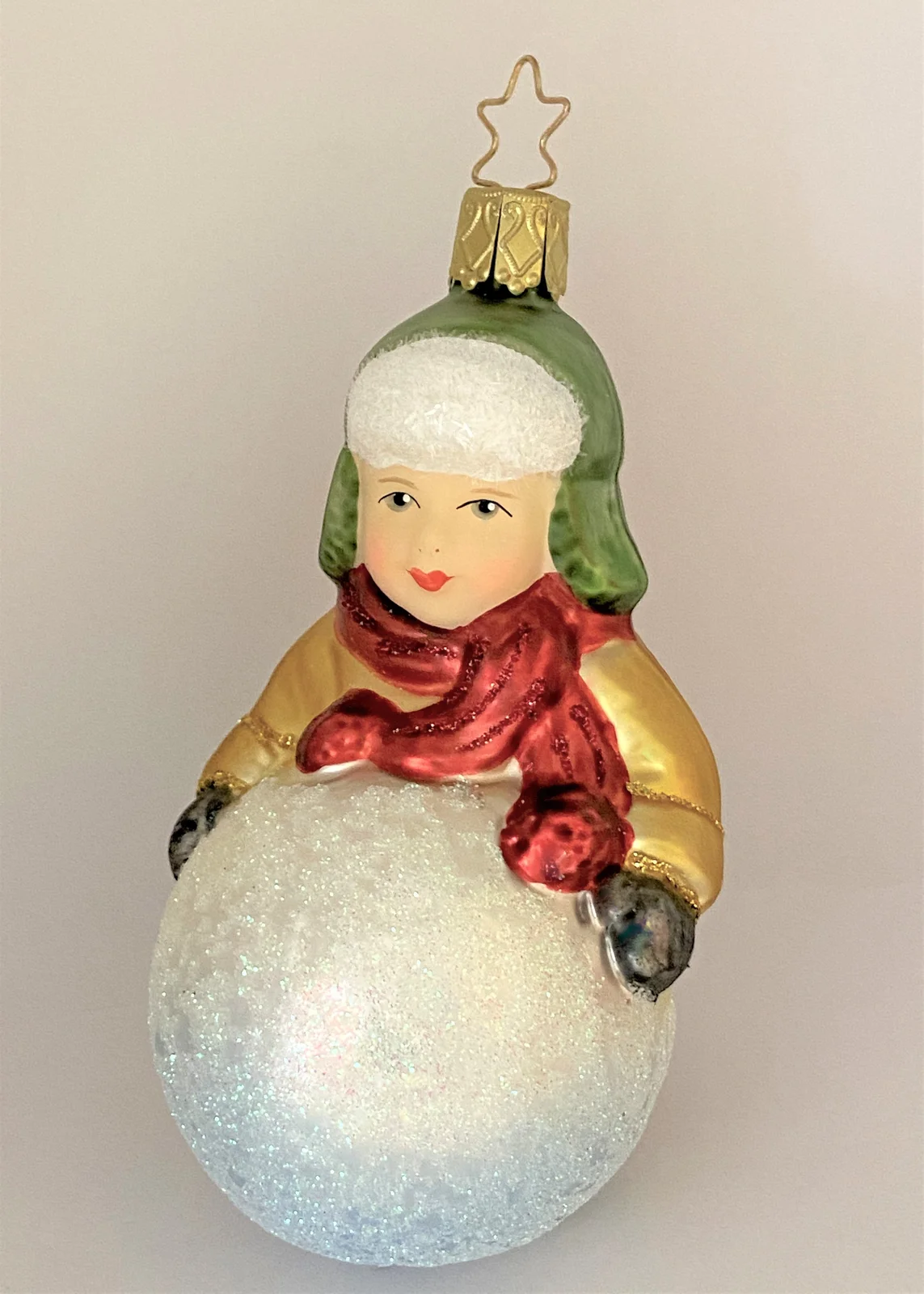 Inge-Glas Kleiner Junge mit grüner Wintermütze macht einen riesigen Schneeball