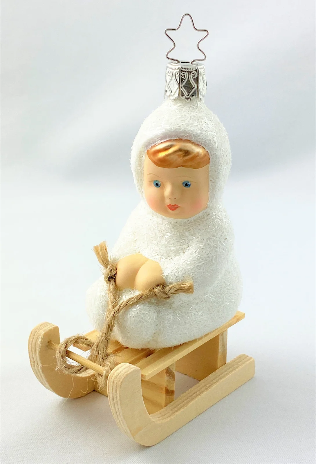 Inge-Glas Schneekind fährt auf dem Schlitten