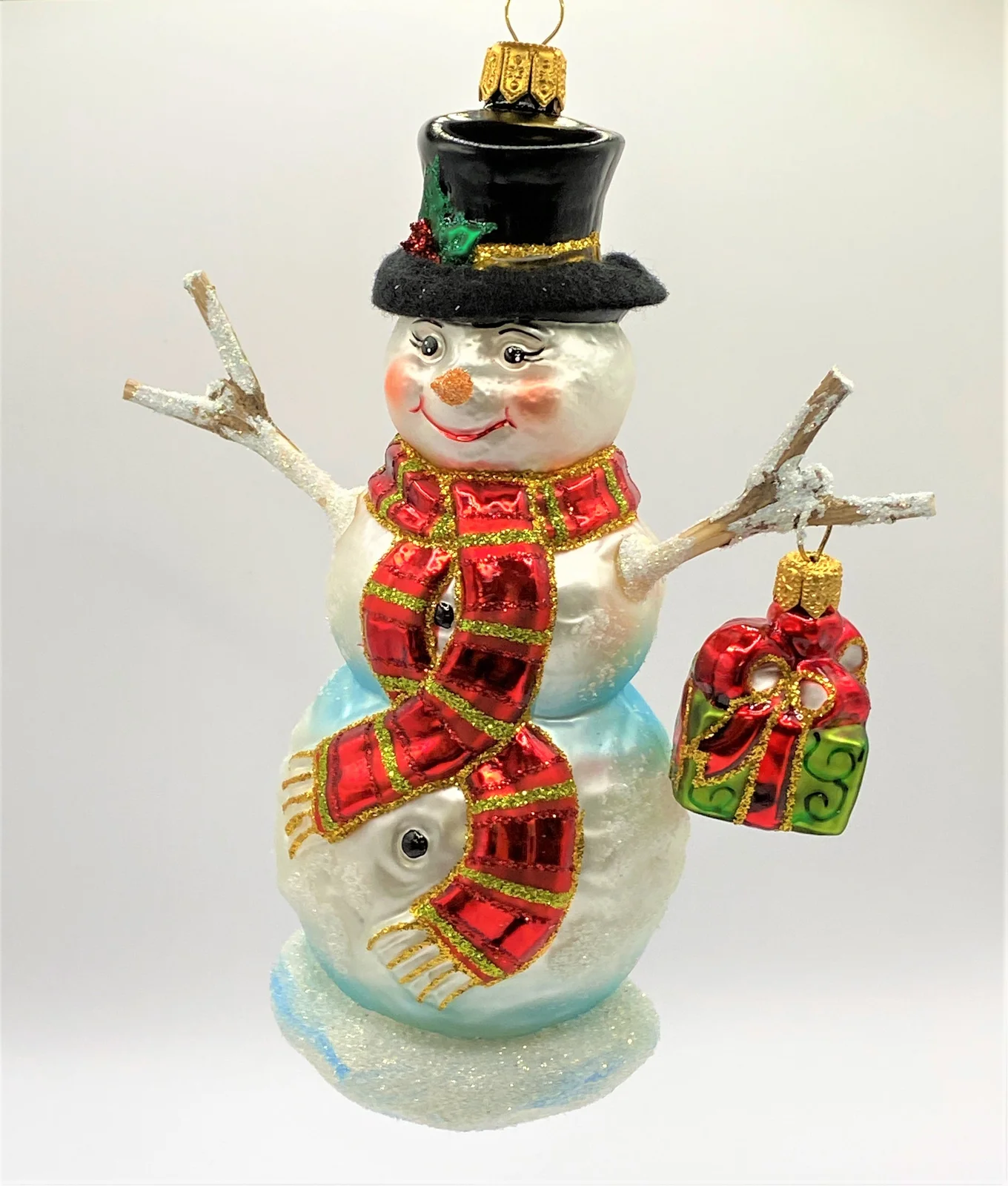Hanco Schneemann mit rotem Schal und Hut und Geschenk