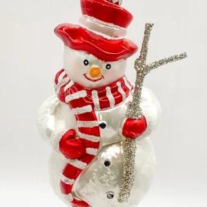 Hanco Schneemann mit rotem Schal und Reisig-Stecken