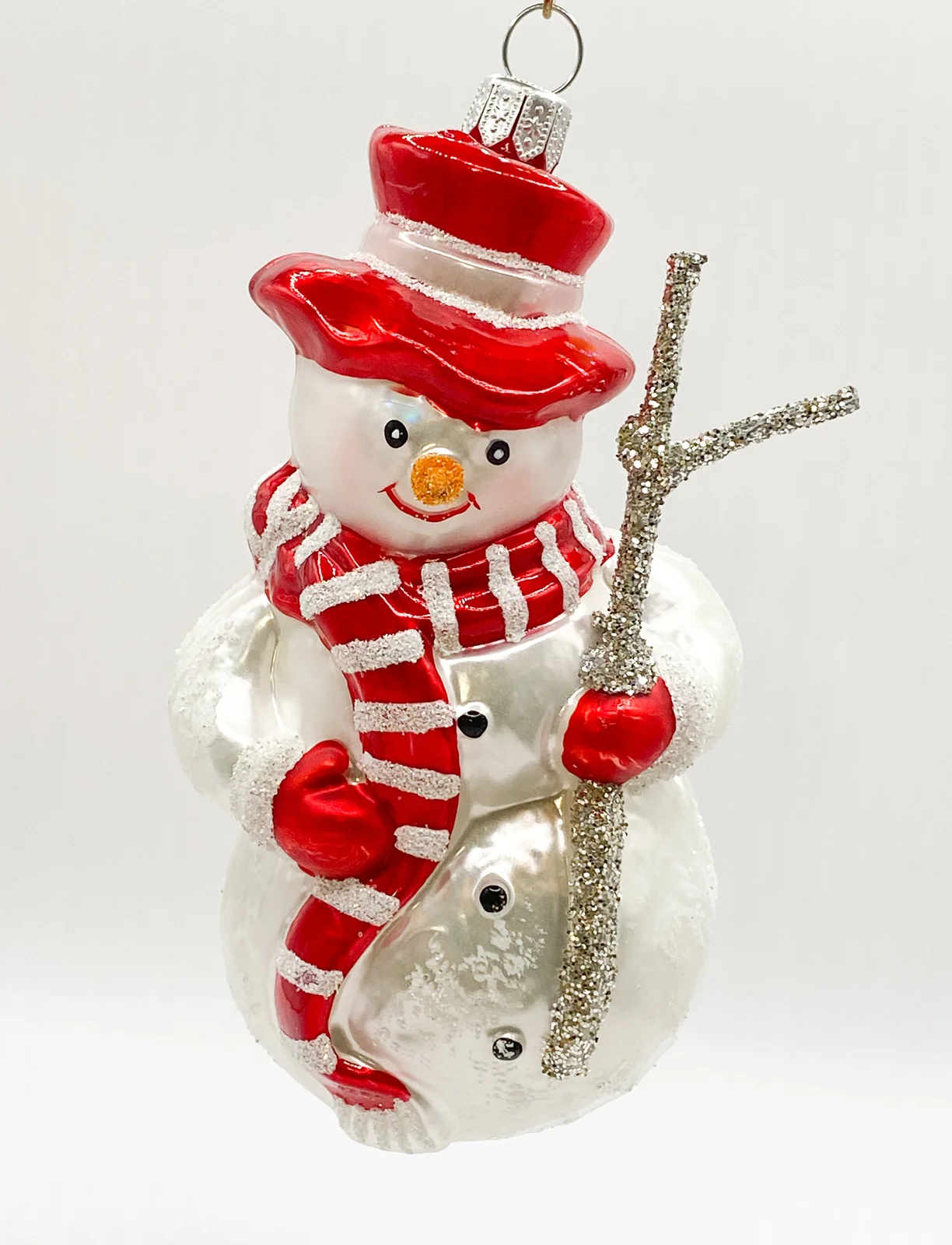 Hanco Schneemann mit rotem Schal und Reisig-Stecken