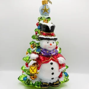 Glassware Schneemann mit Laterne steht vor dem Weihnachtsbaum