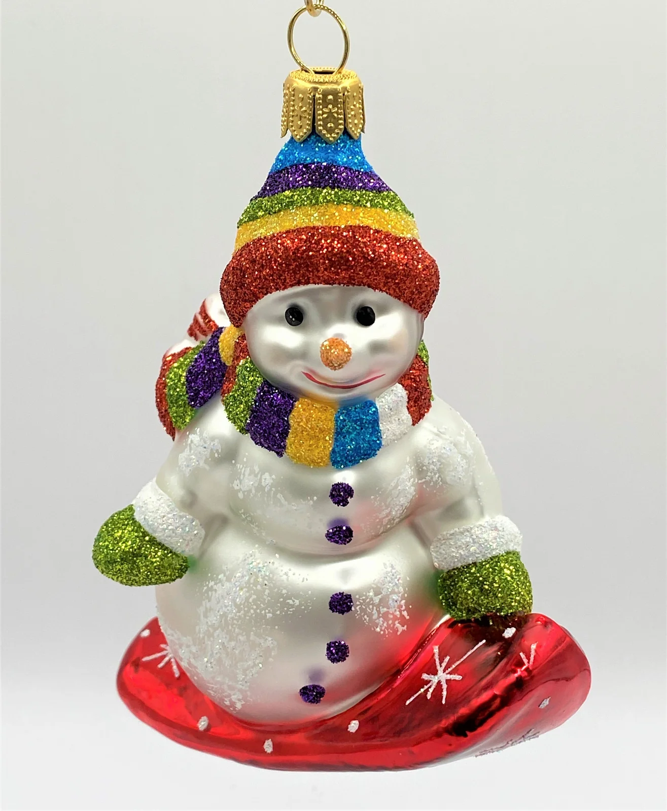 Hanco Schneemann mit bunter Mütze auf Snowboard