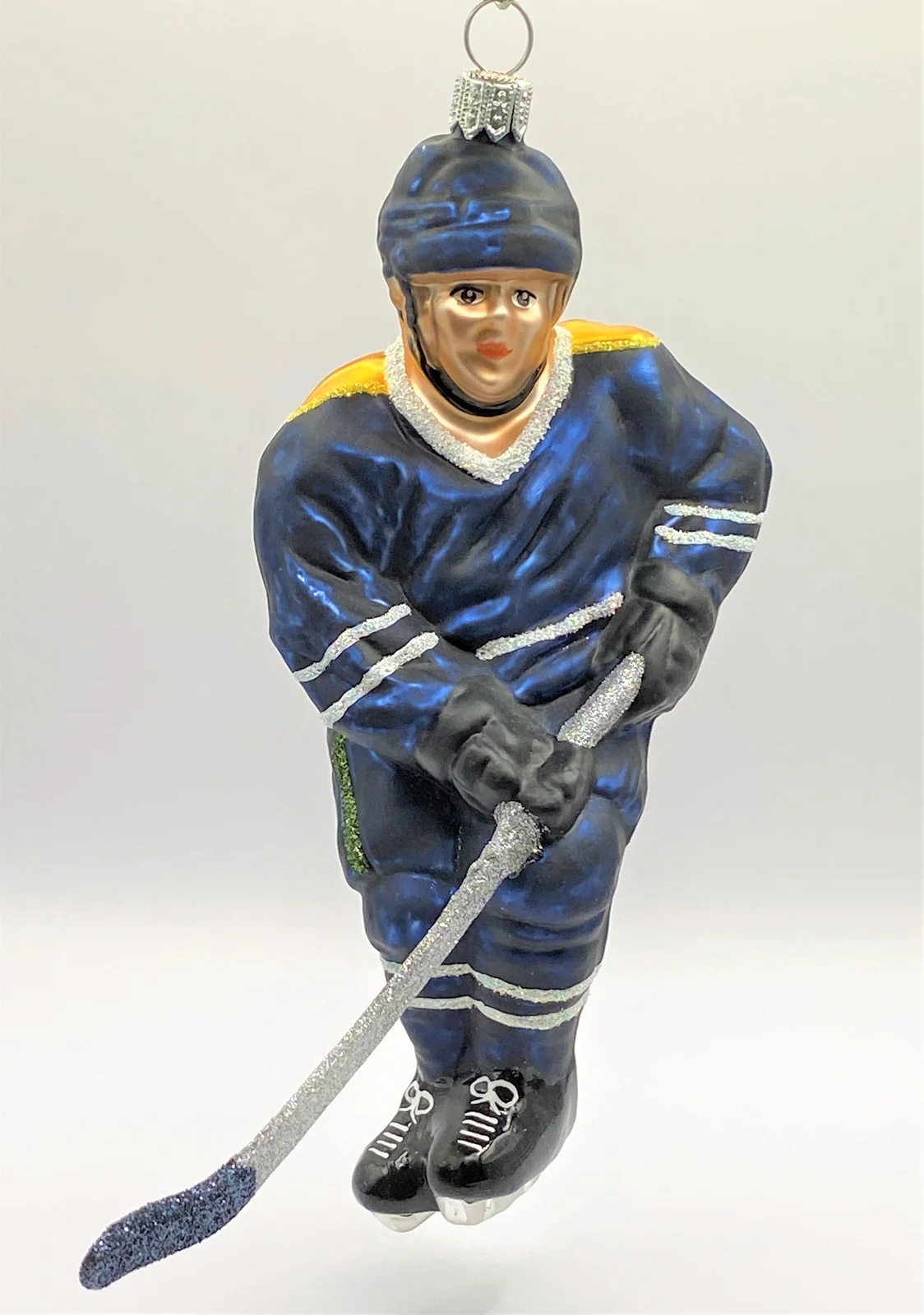 Hanco Schweizer Eishockey Spieler in dunkelblauem Trikot mit gelbem Streifen