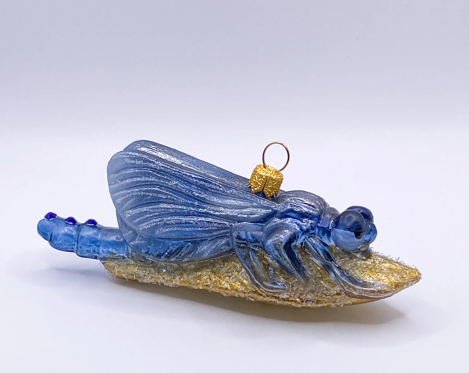 GMC Libelle sitzt auf dem goldenen Blatt, blau