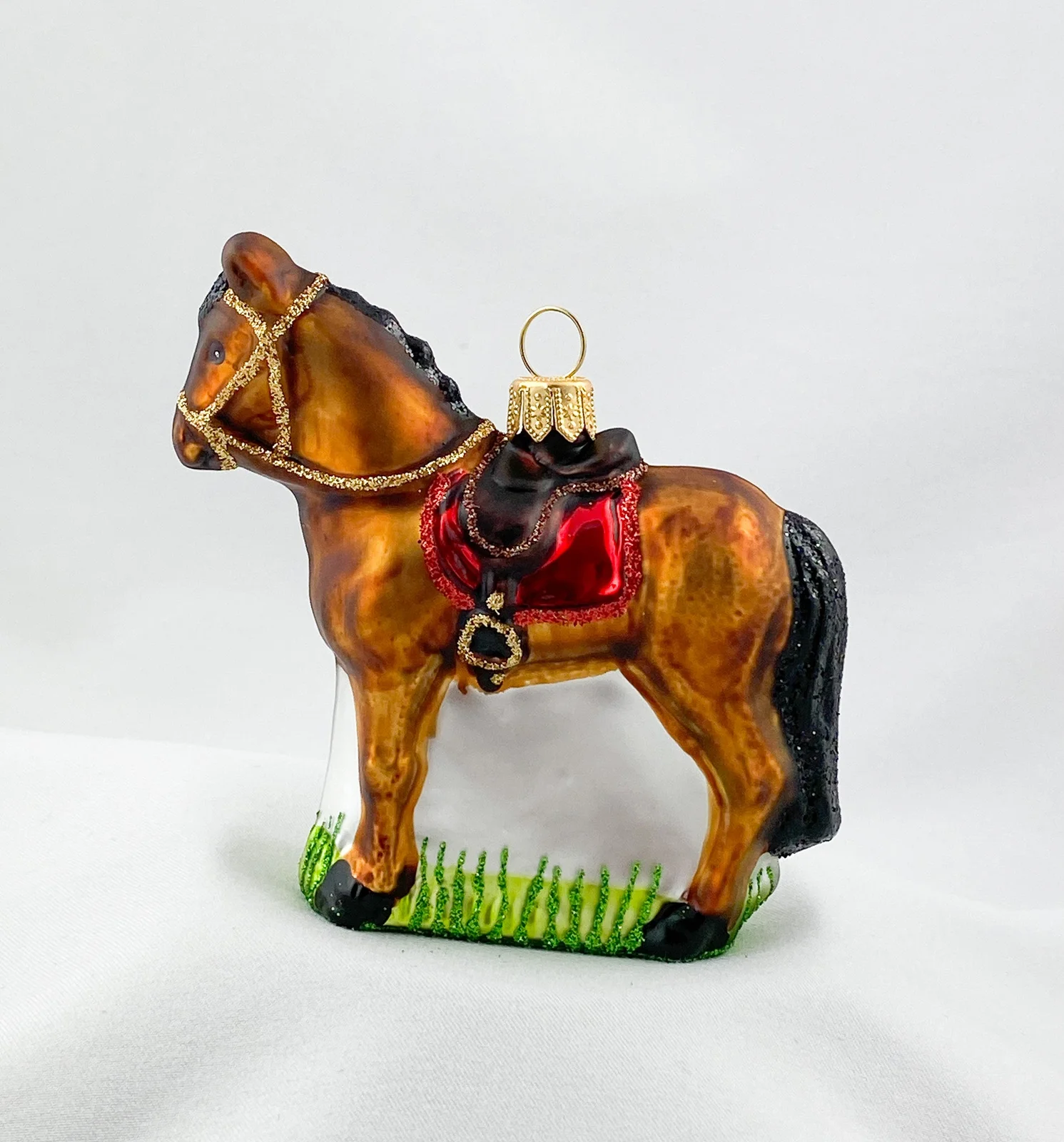 Glaspol Braunes Pferd mit roter Satteldecke