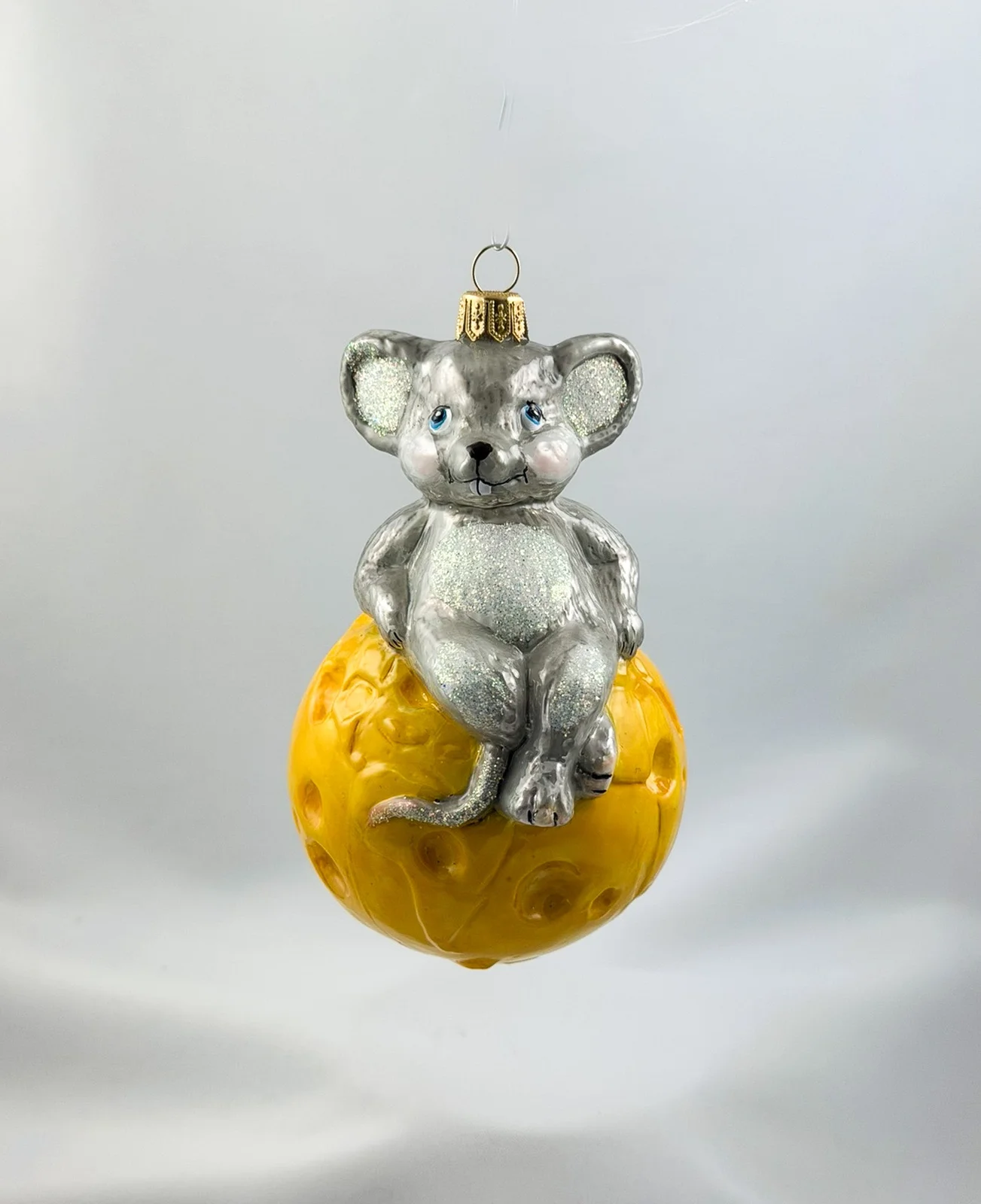 Impuls Die Maus sitzt gemütlich auf dem Käse-Globus