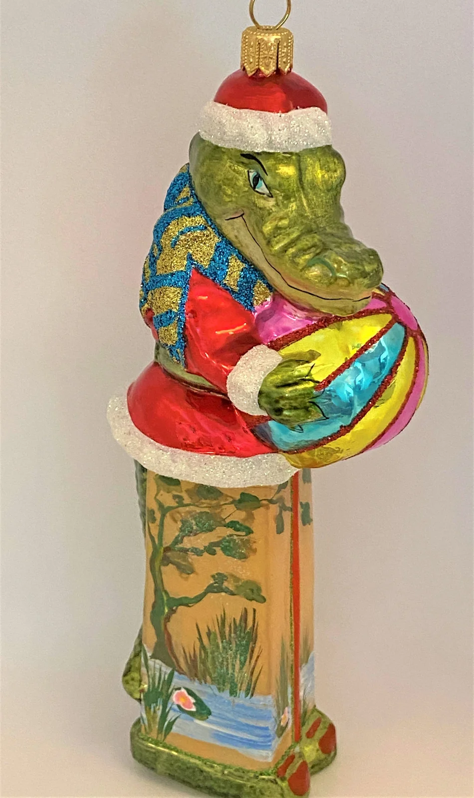 Glassware Krokodil im Santa-Kostüm spielt mit dem Ball