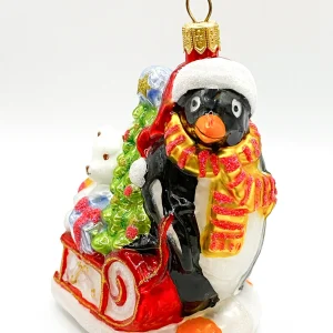 Glassware Pinguin bringt den Weihnachtsbaum und Geschenke auf dem Schlitten