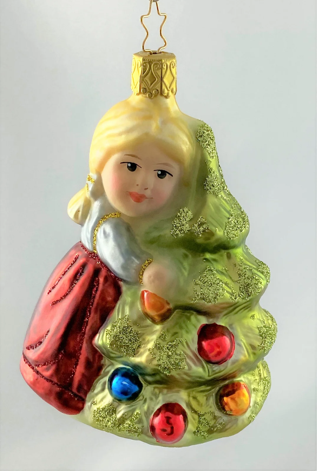Inge-Glas Das kleinen Mädchen umarmt den Christbaum