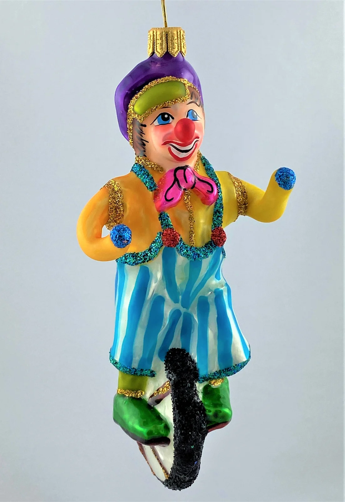 Wiktoria Clown in gestreifter Hose fährt Einrad