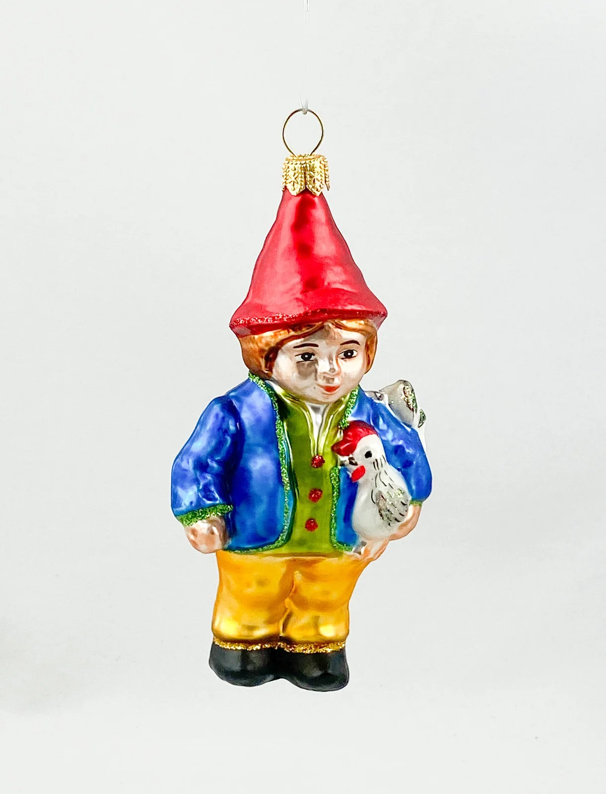 Hanco Zwerg in blauer Jacke mit Huhn unter dem Arm